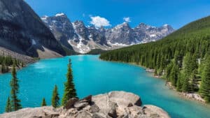 Turquoise waters of the Moraine Lake with snow-covered peaks above it in Rocky Mountains, Banff National Park, Canada.