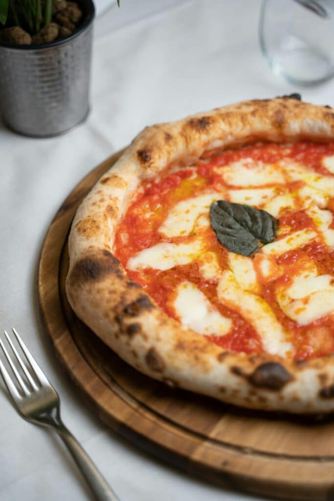 Classic Neapolitan Margherita, blistered and basil-topped.