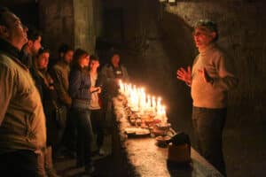 Optional candle-lit passage through narrow tunnel
