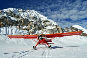 Red plane landing on a Glacier in Denali Mountains