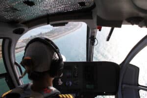 Helicopter pilot flights the helicopter on the Palm Jumeirah in Dubai, UAE